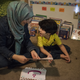 Walaa teaches Arabic to her son.